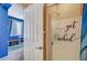 A bathroom offers a decorative shower door, bright blue walls, and white tile flooring at 1413 Miller Ridge Ave, North Las Vegas, NV 89031