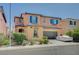 Two-story home showcasing colorful exterior, tidy landscaping, and two-car garage at 1413 Miller Ridge Ave, North Las Vegas, NV 89031