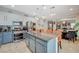 Modern kitchen features stainless steel appliances, granite counters, white cabinetry and island seating at 1413 Miller Ridge Ave, North Las Vegas, NV 89031