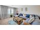 Cozy living room featuring a comfortable blue sofa, wooden coffee table, and lots of natural light at 1413 Miller Ridge Ave, North Las Vegas, NV 89031