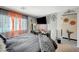 Bright main bedroom featuring grey walls, orange curtains, TV, and decorative wall accents at 1413 Miller Ridge Ave, North Las Vegas, NV 89031