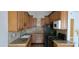 Kitchen featuring brown cabinets, granite countertops, tile backsplash, and black appliances at 1612 N Torrey Pines Dr # 104, Las Vegas, NV 89108