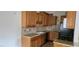 Well-equipped kitchen with brown cabinets, granite countertops, stainless steel sink, and black appliances at 1612 N Torrey Pines Dr # 104, Las Vegas, NV 89108