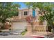 Charming two-story home with a well-maintained front yard and a two-car garage on a sunny day at 2057 Wandering Doe Ln, Las Vegas, NV 89134