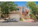 Charming two-story home with a well-maintained front yard and a two-car garage on a sunny day at 2057 Wandering Doe Ln, Las Vegas, NV 89134