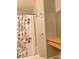 Cozy bathroom with a white floral shower curtain, wood paneling, and tile flooring at 23 E Agate Ave # 403, Las Vegas, NV 89123