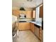 Well-lit kitchen featuring light wood cabinets, tile floors, stainless steel appliances, and granite countertops at 23 E Agate Ave # 403, Las Vegas, NV 89123
