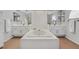 Bright primary bathroom with double sinks, white tile, a large soaking tub, and modern fixtures at 2699 Aldonza Dr, Henderson, NV 89014