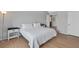 Neutral bedroom with king bed and two bedside tables and lamps with wood flooring throughout at 2699 Aldonza Dr, Henderson, NV 89014