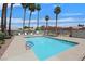 Community pool with pool furniture, landscaping, and mature palm trees at 2699 Aldonza Dr, Henderson, NV 89014