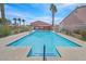 Community pool with seating, landscaping, and mature palm trees at 2699 Aldonza Dr, Henderson, NV 89014