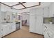 Bright kitchen featuring white cabinetry, tile countertops, and wood-look flooring at 2699 Aldonza Dr, Henderson, NV 89014