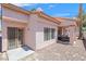A cozy, gravel-covered patio with a stucco wall and a covered seating area with grill at 2699 Aldonza Dr, Henderson, NV 89014