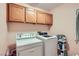 This laundry room includes overhead cabinets and a full-size washer and dryer at 2708 Campo Verde Dr, Las Vegas, NV 89121