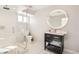 Modern bathroom with glass-enclosed shower, sleek vanity, and large round mirror at 2890 Belcastro St, Las Vegas, NV 89117