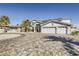 Elegant two-story home with a three-car garage, paved driveway, and mature palm trees at 2890 Belcastro St, Las Vegas, NV 89117