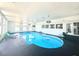 Bright indoor pool area features a blue in-ground pool, lounge chair, and recessed lighting at 2890 Belcastro St, Las Vegas, NV 89117