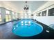 Bright indoor pool area features a blue in-ground pool, lounge chair, and chandelier lighting at 2890 Belcastro St, Las Vegas, NV 89117