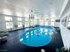 Bright indoor pool area features a blue in-ground pool, lounge chair, and many windows at 2890 Belcastro St, Las Vegas, NV 89117