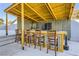 Outdoor bar area under a covered structure with a TV, seating for five, and modern finishes at 2890 Belcastro St, Las Vegas, NV 89117
