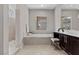 Elegant bathroom featuring a soaking tub, tiled shower, and vanity at 2890 Reverence Heights Ln, Las Vegas, NV 89138
