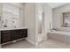Luxurious bathroom with large soaking tub, shower, and vanity with dark wood cabinets at 2890 Reverence Heights Ln, Las Vegas, NV 89138