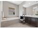 Elegant bathroom featuring a soaking tub, vanity, and neutral tile at 2890 Reverence Heights Ln, Las Vegas, NV 89138