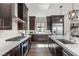 Modern kitchen with stainless steel appliances, white countertop, and dark wood cabinetry at 2890 Reverence Heights Ln, Las Vegas, NV 89138