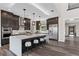Modern kitchen features dark wood cabinetry, a large island with seating, and stainless steel appliances at 2890 Reverence Heights Ln, Las Vegas, NV 89138