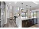 Open concept kitchen with large island, stainless steel appliances, and view of the living room fireplace at 2890 Reverence Heights Ln, Las Vegas, NV 89138