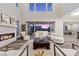 Elegant living room with fireplace, high ceilings, and floor to ceiling doors to the patio at 2890 Reverence Heights Ln, Las Vegas, NV 89138