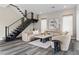 Inviting living area with wood floors, comfortable seating, and modern staircase enhancing the contemporary design at 2890 Reverence Heights Ln, Las Vegas, NV 89138
