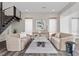 Well-lit living room featuring wood floors, neutral-toned furniture, modern art, and stair access to the second level at 2890 Reverence Heights Ln, Las Vegas, NV 89138