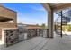 Beautiful outdoor kitchen featuring stone accents, stainless steel grill, and spiral staircase access to roof deck at 2890 Reverence Heights Ln, Las Vegas, NV 89138