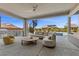 Inviting covered patio with outdoor seating, spiral staircase, and summer kitchen overlooking a sparkling pool at 2890 Reverence Heights Ln, Las Vegas, NV 89138