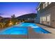 Beautiful pool and jacuzzi with outdoor lighting and mountain views at dusk at 2890 Reverence Heights Ln, Las Vegas, NV 89138