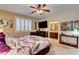 Inviting bedroom featuring a ceiling fan, TV, and ensuite bathroom access at 2958 Lapis Beach Dr, Las Vegas, NV 89117