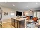Kitchen island with granite countertop and seating that opens to living and dining area at 2958 Lapis Beach Dr, Las Vegas, NV 89117