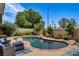 Backyard pool with lush landscaping and comfortable seating area at 2958 Lapis Beach Dr, Las Vegas, NV 89117