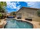 Backyard pool with a rock border, a tiki bar, and comfortable seating area at 2958 Lapis Beach Dr, Las Vegas, NV 89117