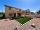 The backyard features synthetic grass, rock landscaping, fencing, and a covered patio at 3412 Catherine Mermet Ave, North Las Vegas, NV 89081
