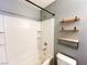 Relaxing bathroom with a white tiled tub, a shower, and decorative shelving for storage and style at 3412 Catherine Mermet Ave, North Las Vegas, NV 89081