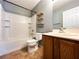 Clean bathroom with white tile tub, a single sink vanity, tile flooring, and modern shelving at 3412 Catherine Mermet Ave, North Las Vegas, NV 89081