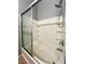 Bathroom tub featuring tile surround, built-in shelving, and a shower with sliding glass doors at 3412 Catherine Mermet Ave, North Las Vegas, NV 89081