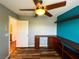 Comfortable bedroom with wood floors, a ceiling fan, built-in shelves, and an ensuite bathroom entrance at 3412 Catherine Mermet Ave, North Las Vegas, NV 89081