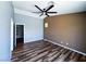 Spacious bedroom featuring dark, wood-like floors, a modern ceiling fan, and neutral color scheme at 3412 Catherine Mermet Ave, North Las Vegas, NV 89081