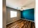 Bedroom featuring wood floors, a ceiling fan, and a bright teal accent wall at 3412 Catherine Mermet Ave, North Las Vegas, NV 89081
