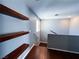 Open hallway with hardwood floors, floating wood shelves, and a staircase with neutral paint at 3412 Catherine Mermet Ave, North Las Vegas, NV 89081