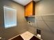 Laundry room with wooden cabinets, wire shelving, and a bright window at 3412 Catherine Mermet Ave, North Las Vegas, NV 89081