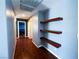 Well-lit upstairs hallway with hardwood floors, floating shelves, and neutral colored walls at 3412 Catherine Mermet Ave, North Las Vegas, NV 89081